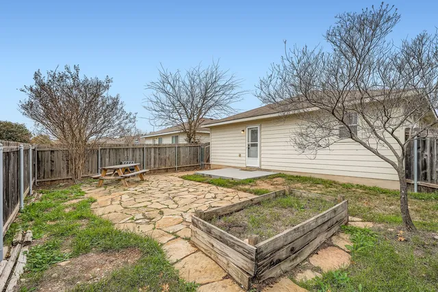 a view of a backyard that has a tree on the side of it