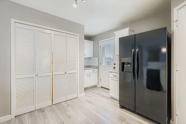 a view of a kitchen with a refrigerator in kitchen and wooden floor