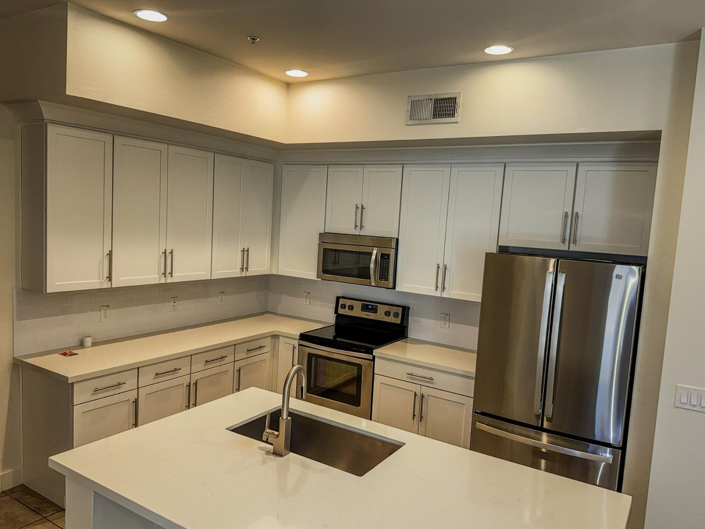 6565 East Thomas Road, Unit 1046 Scottsdale, AZ 85251 - Photo 3 of 16 a kitchen with a refrigerator a stove top oven a sink and cabinets