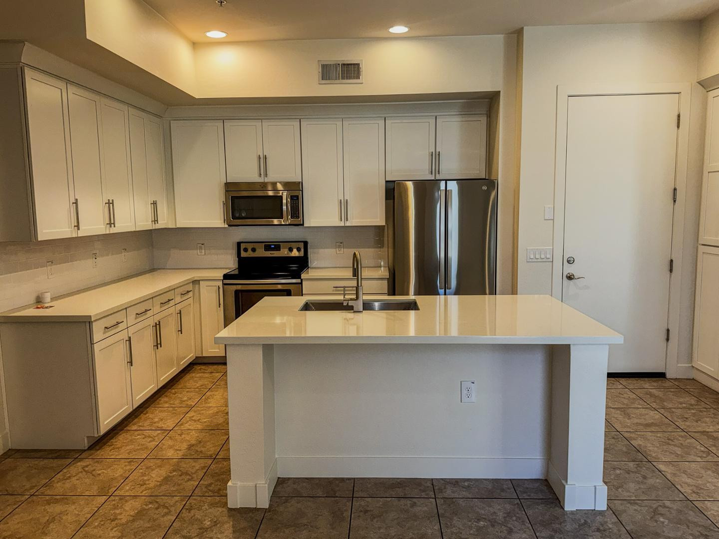 6565 East Thomas Road, Unit 1046 Scottsdale, AZ 85251 - Photo 6 of 16 a kitchen with kitchen island white cabinets and stainless steel appliances