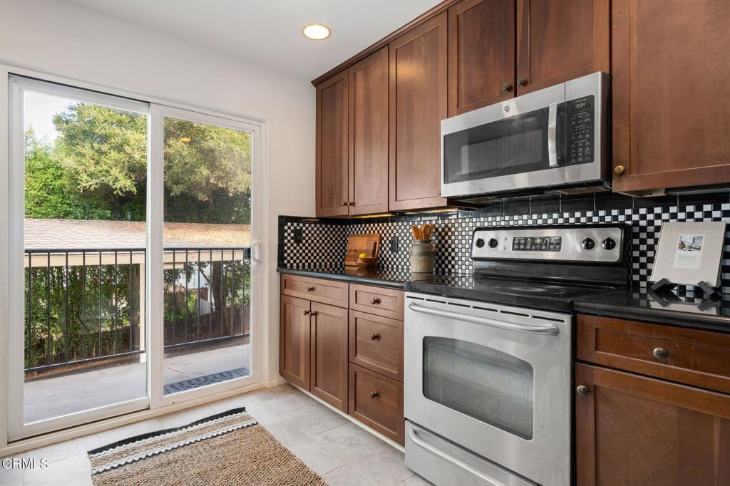 3914 Via Lucero, Unit B Santa Barbara, CA 93110 - Photo 11 of 22 a kitchen with granite countertop a stove top oven cabinetry a sink and a microwave