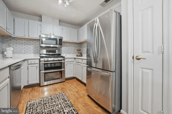 a kitchen with stainless steel appliances a refrigerator stove and sink