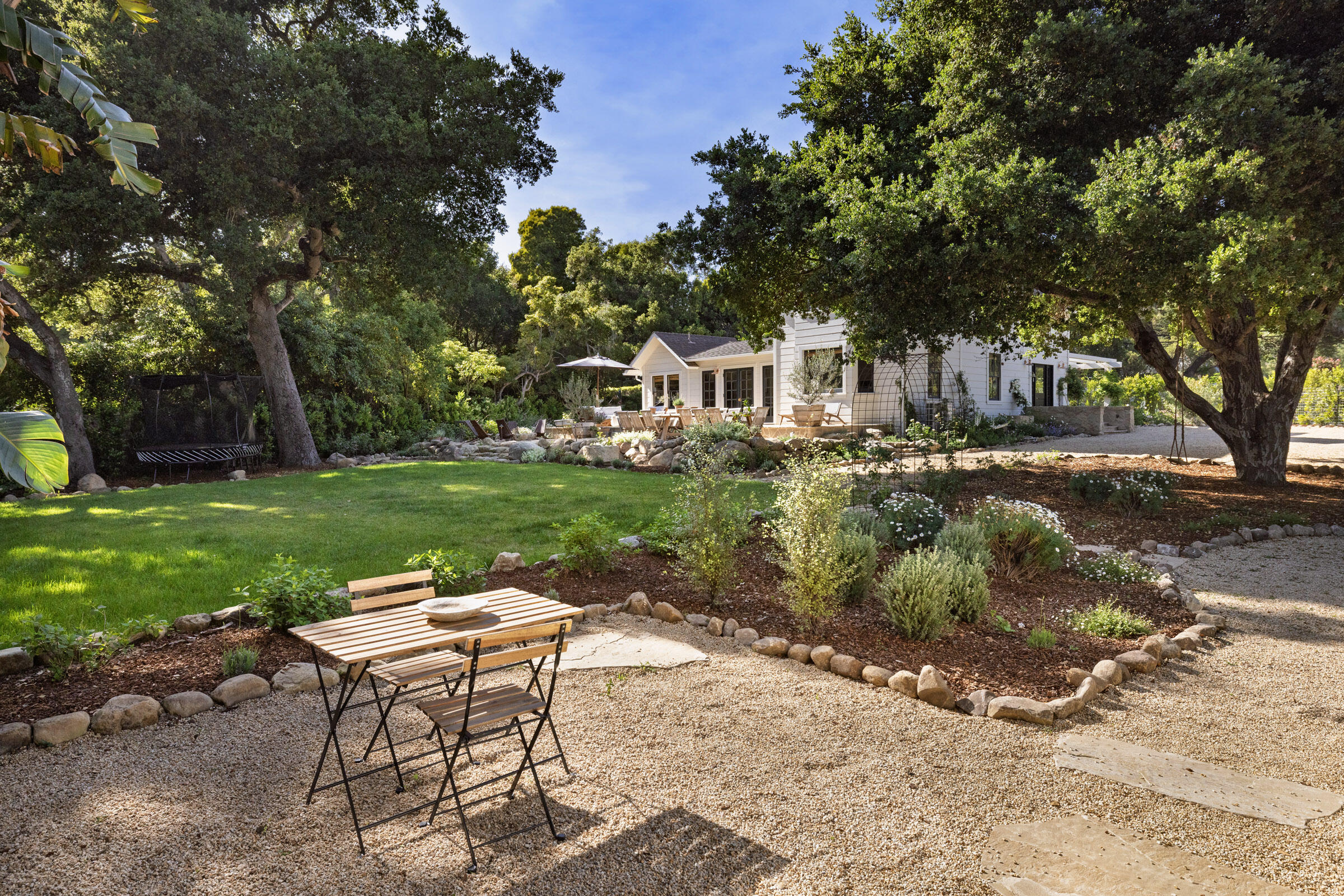 1575 East Valley Road Montecito, CA 93108 - Photo 3 of 30 a backyard of a house with table and chairs