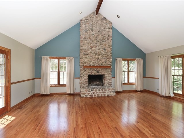 243 Bradwell Road Inverness, IL 60010 - Photo 10 of 25 an empty room with wooden floor a fireplace and windows