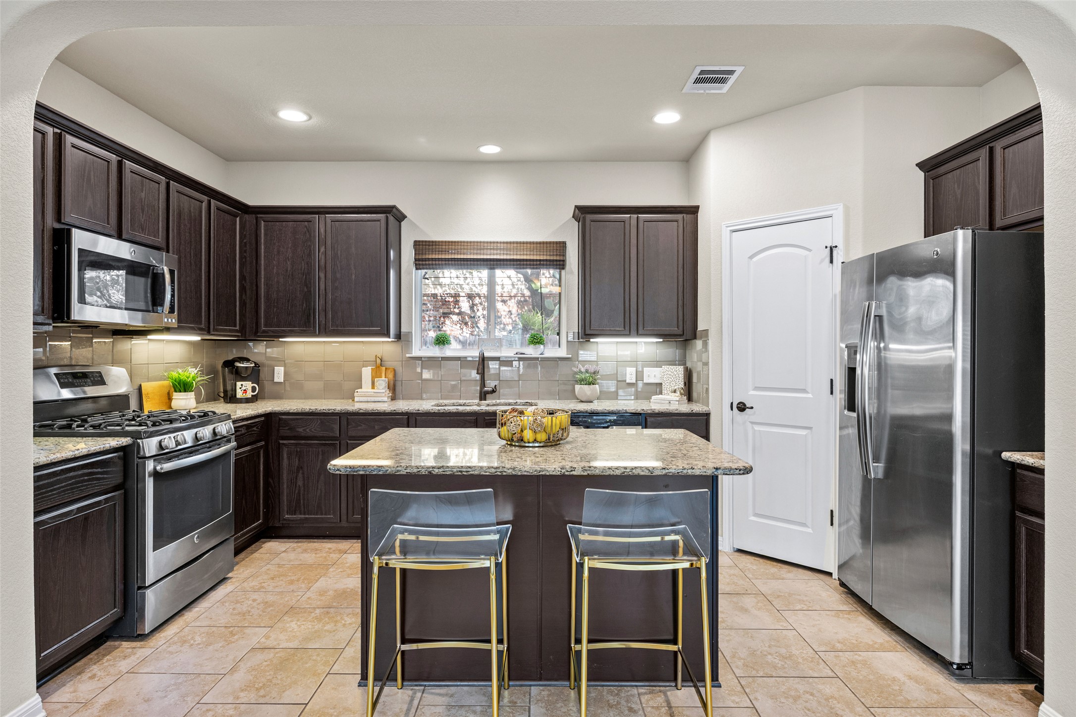 3451 Mayfield Ranch Boulevard, Unit 201 Round Rock, TX 78681 - Photo 7 of 29 a kitchen with stainless steel appliances granite countertop a stove top oven a refrigerator a sink and dishwasher