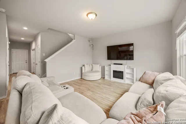 a living room with furniture a fireplace and a flat screen tv