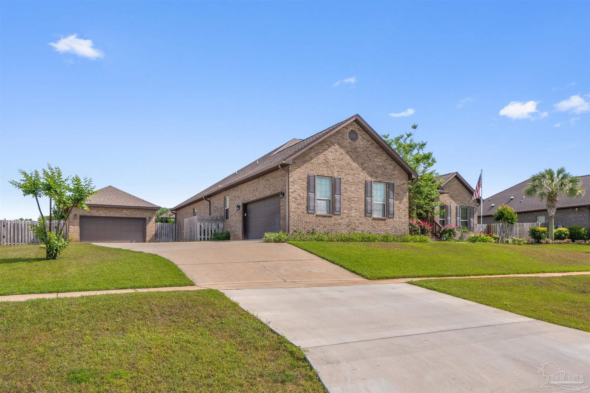 2698 Tulip Hill Road Pace, FL 32571 - Photo 2 of 65 a front view of a house with a yard and garage