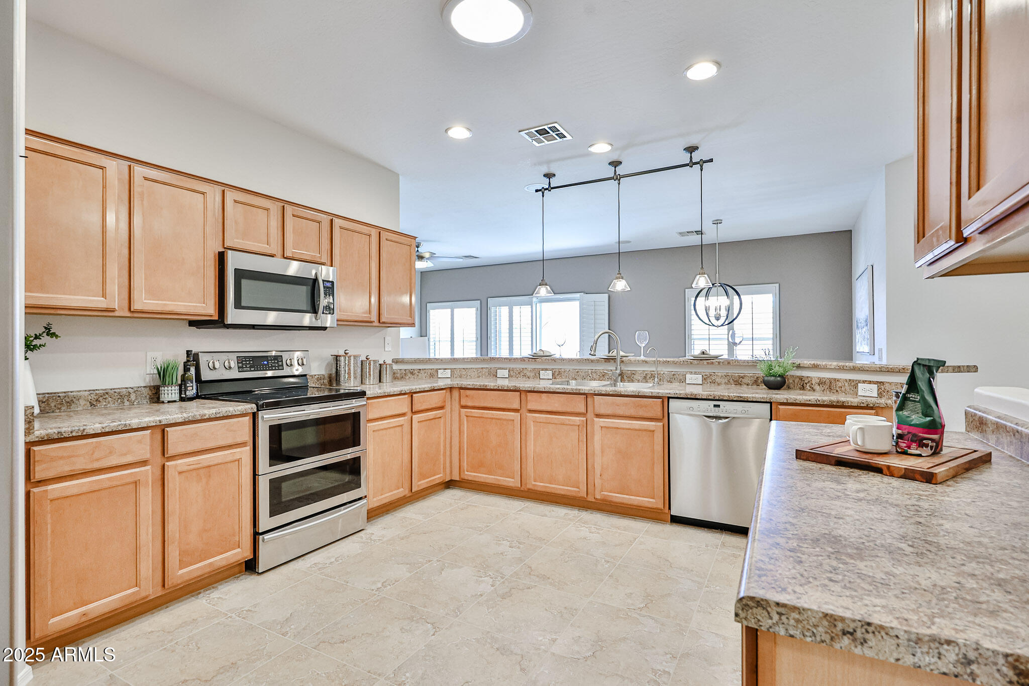 15731 West Redfield Road Surprise, AZ 85379 - Photo 11 of 48 a kitchen with kitchen island granite countertop a stove top oven a sink dishwasher and white cabinets with wooden floor