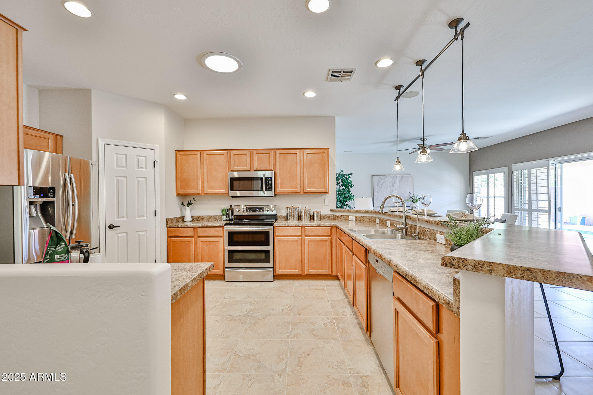 15731 West Redfield Road Surprise, AZ 85379 - Photo 14 of 48 a kitchen with stainless steel appliances kitchen island granite countertop a sink stove and refrigerator