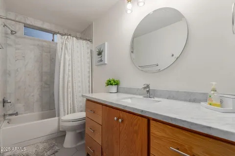 a bathroom with a granite countertop sink a toilet and bathtub