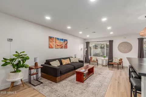 a living room with furniture a potted plant and a table