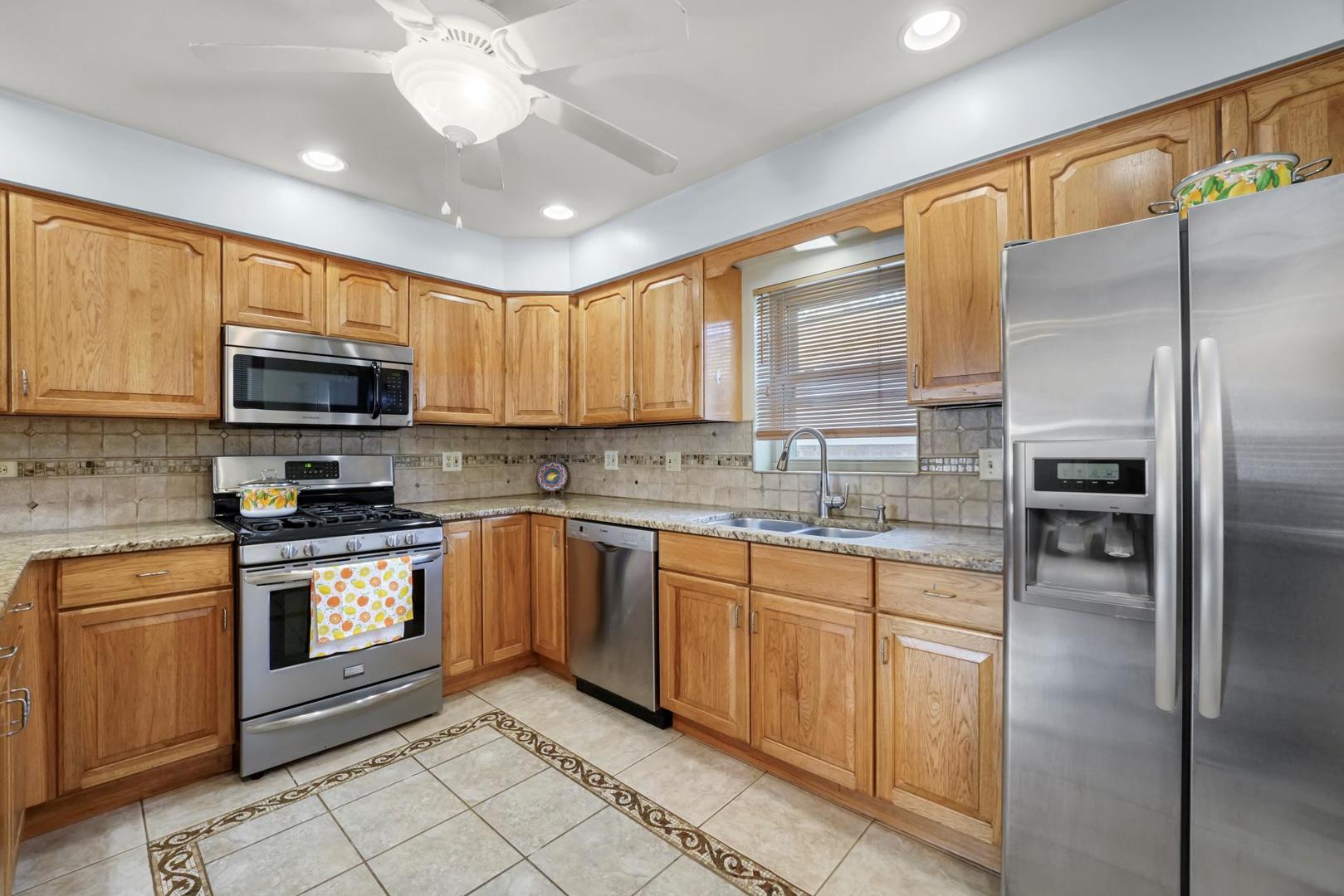 5751 South Monitor Avenue Chicago, IL 60638 - Photo 10 of 30 a kitchen with stainless steel appliances granite countertop a stove sink microwave and refrigerator