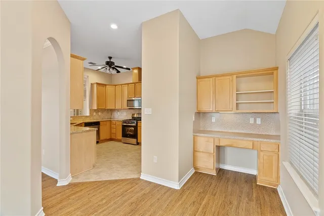 a view of a kitchen with a sink a refrigerator and wooden floor
