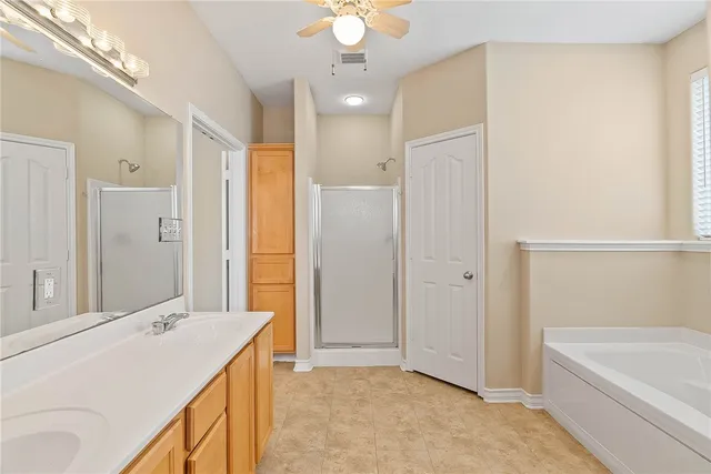 a bathroom with a tub sink and mirror