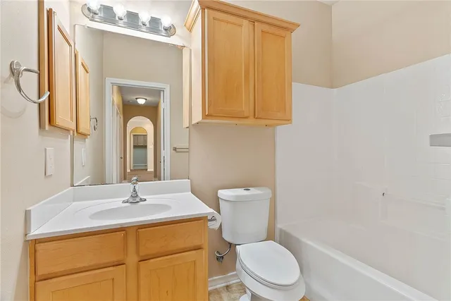 a bathroom with a sink vanity mirror and toilet