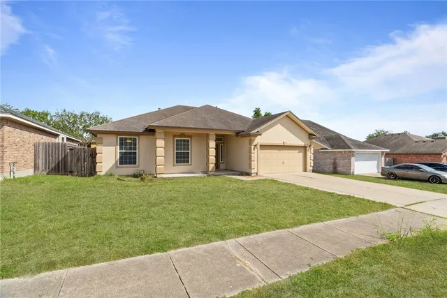 a view of a yard in front of a house with large trees