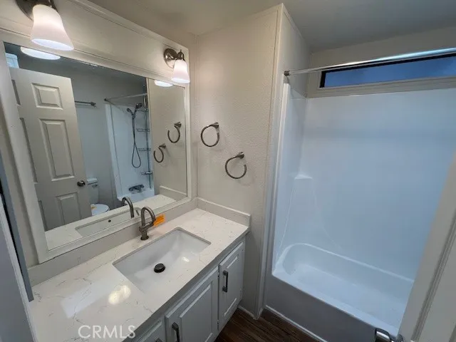 a bathroom with a sink a tub and a mirror
