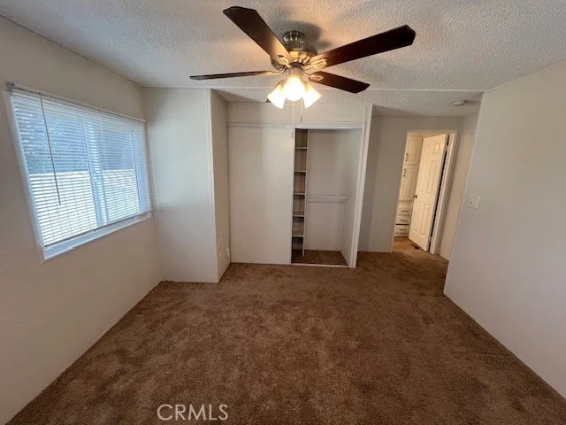 an empty room with closet and windows