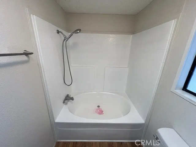 a white bath tub sitting next to a white sink and a shower