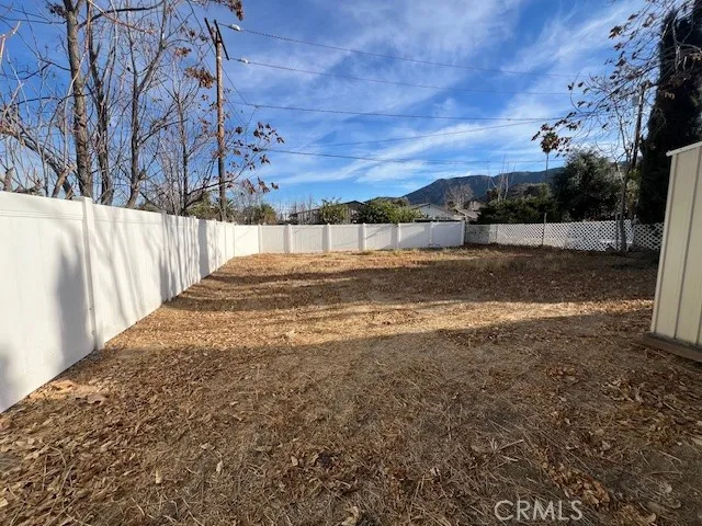 a view of a yard with wooden fence