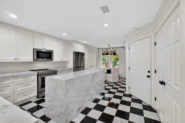 a kitchen with stainless steel appliances a refrigerator and a stove top oven