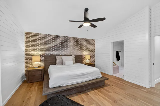 a bedroom with a bed and a ceiling fan