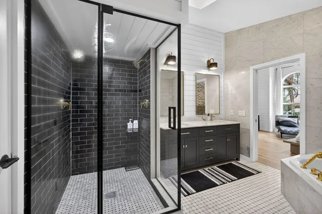a bathroom with a glass door shower a sink and a mirror