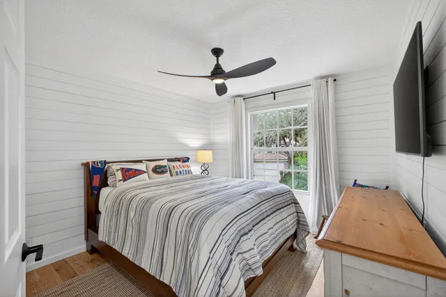 a bedroom with a bed and a flat tv screen on dresser