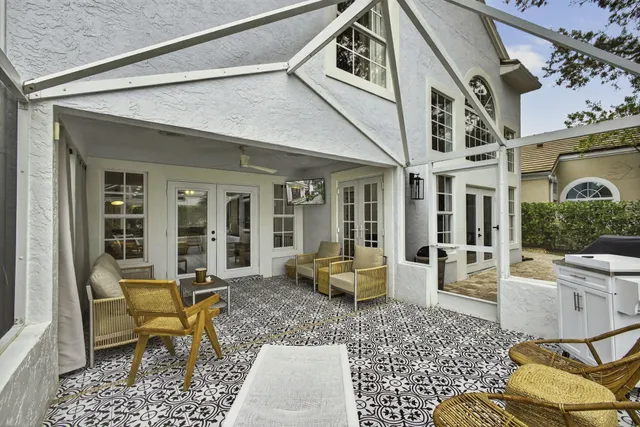a view of a patio with couches table and chairs and potted plants