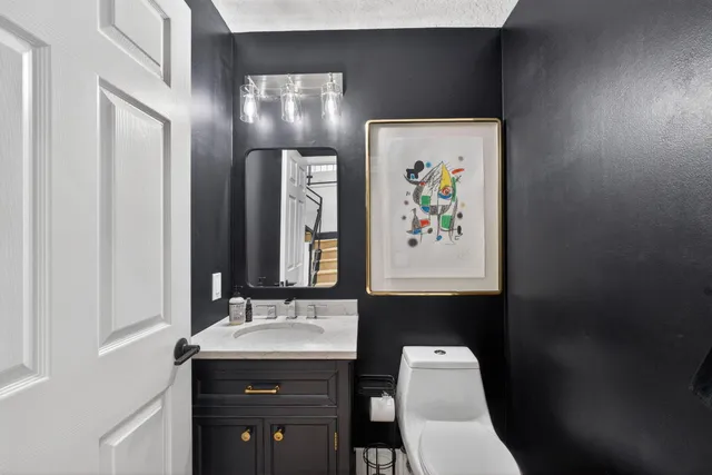 a bathroom with a toilet sink and mirror