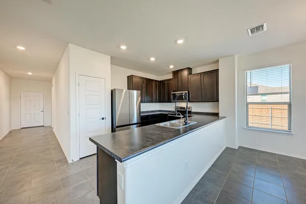 a kitchen with kitchen island a sink stainless steel appliances and cabinets