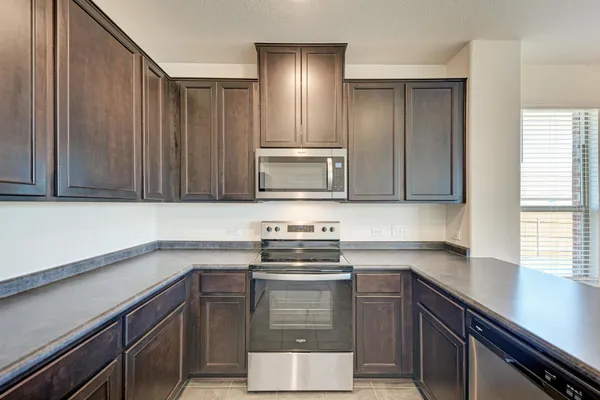 an empty room with chandelier fan and windows