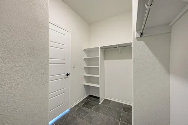 an empty room with a ceiling fan and window