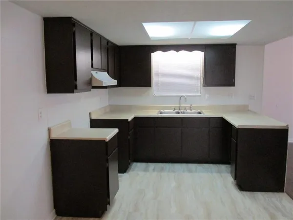 a kitchen with a sink and a wooden cabinets