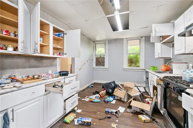 a kitchen that has a lot of cabinets a stove and a window