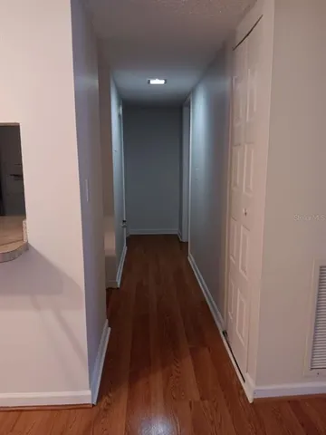 a view of a hallway with wooden floor