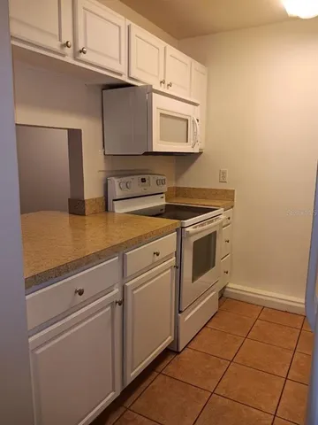 a kitchen with white cabinets and white appliances