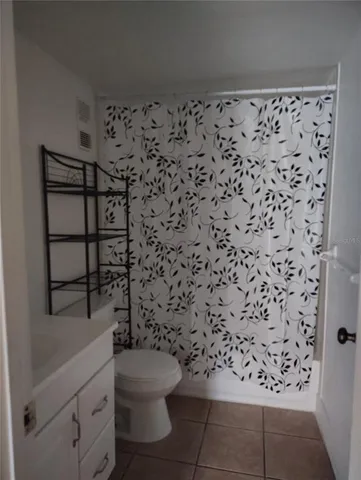 a bathroom with a toilet and a shower curtain