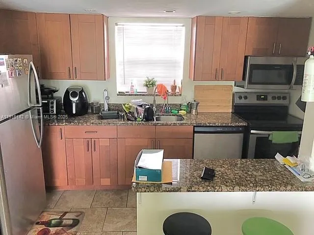 a kitchen with stainless steel appliances granite countertop a refrigerator sink and stove