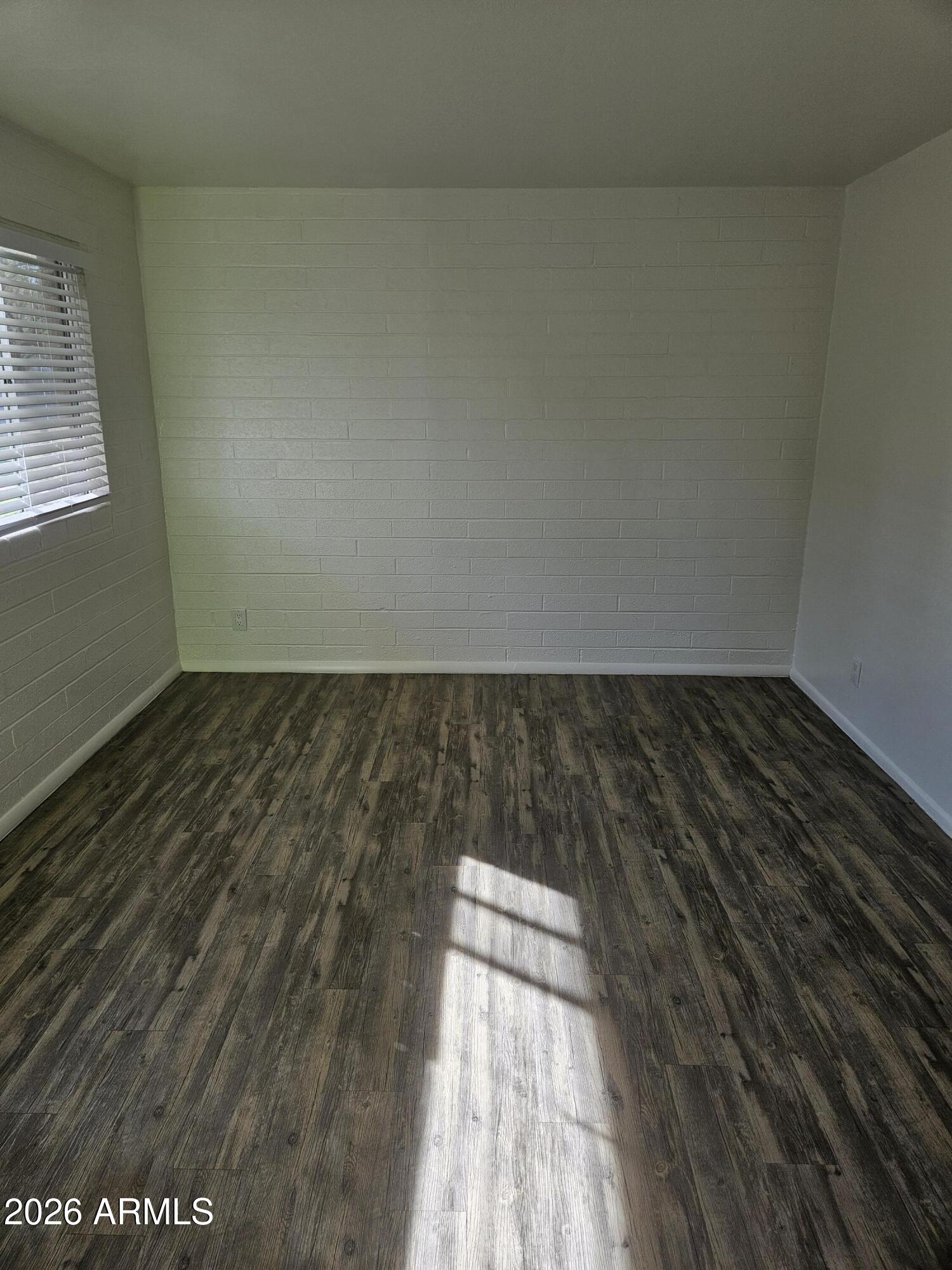 1418 East Osborn Road, Unit 25A Phoenix, AZ 85014 - Photo 3 of 13 an empty room with wooden floor