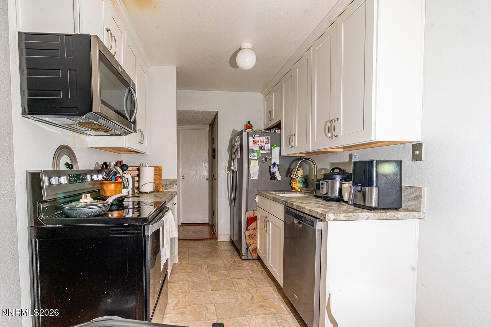 4608 Neil Road, Unit 215 Reno, NV 89502 - Photo 14 of 17 a kitchen with stainless steel appliances granite countertop a stove and a sink