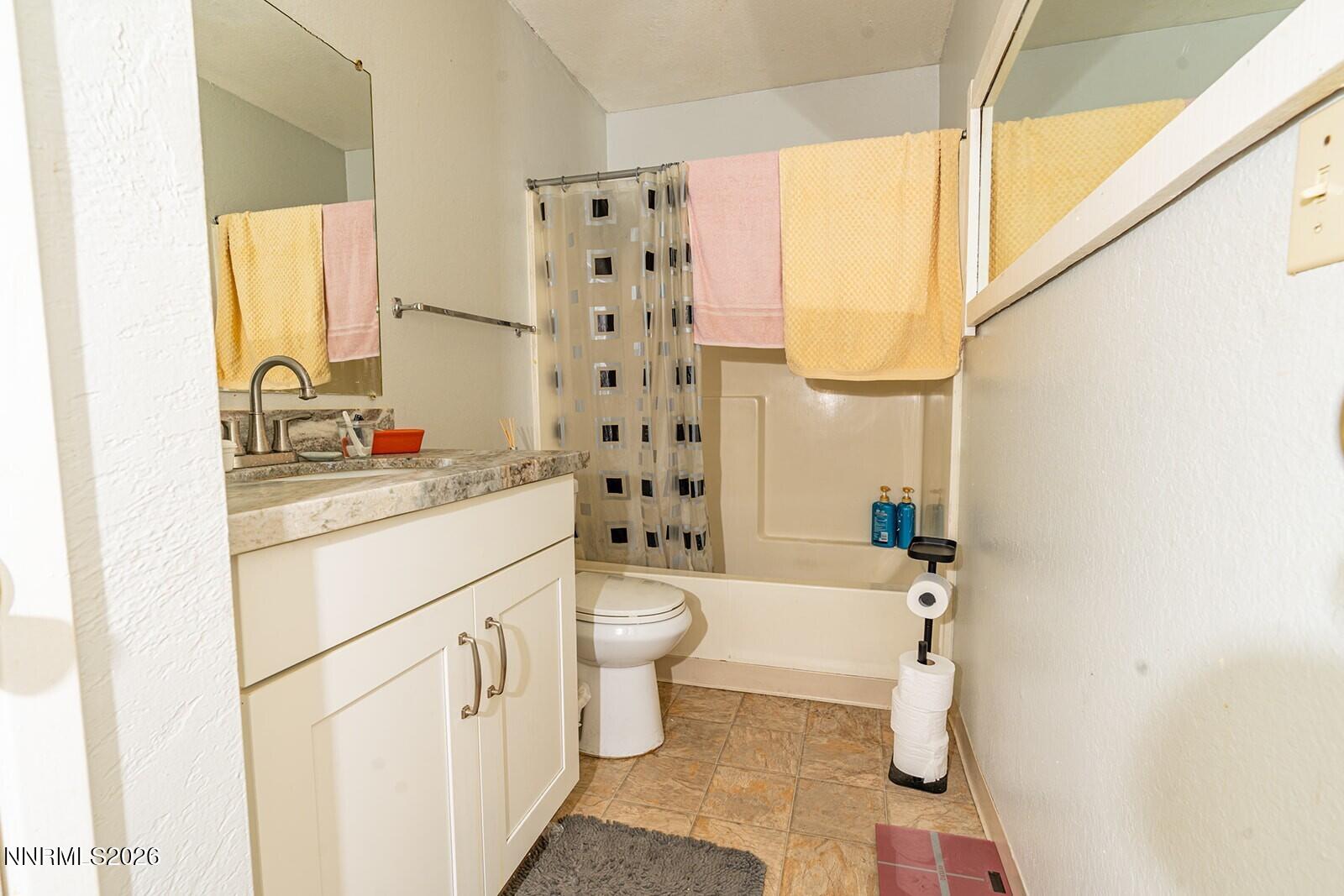 4608 Neil Road, Unit 215 Reno, NV 89502 - Photo 19 of 22 a bathroom with a sink toilet a mirror and shower