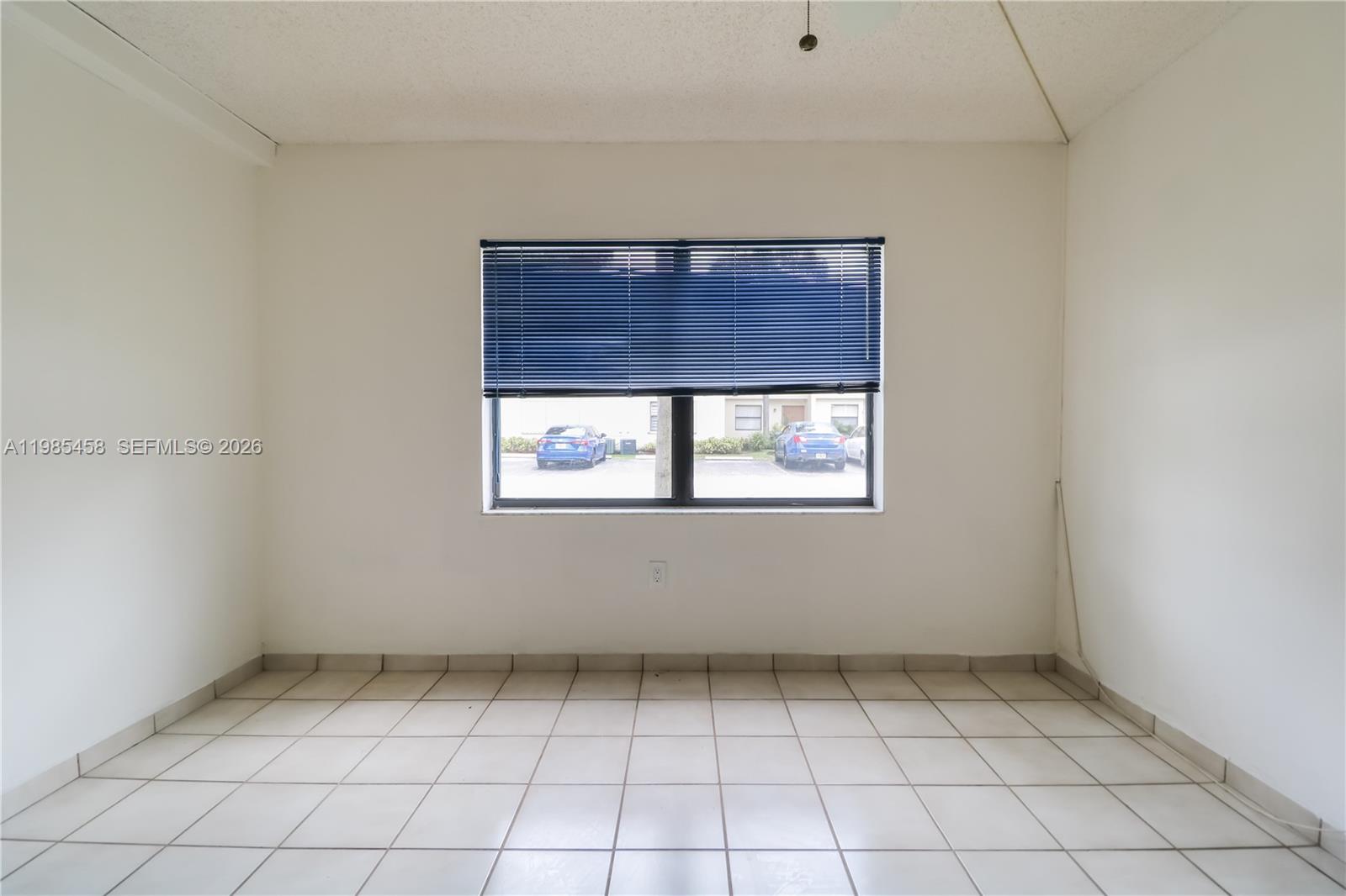 12955 Southwest 66th Lane, Unit 2122 Miami, FL 33183 - Photo 11 of 16 a view of an empty room with a window