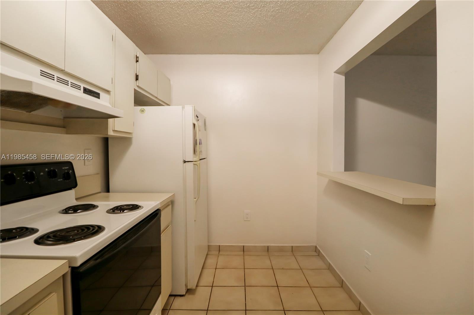 12955 Southwest 66th Lane, Unit 2122 Miami, FL 33183 - Photo 7 of 16 a kitchen with a stove and a microwave