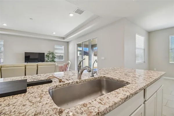 a kitchen with granite countertop sink and cabinets