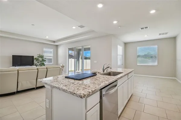 a kitchen with granite countertop a sink and cabinets