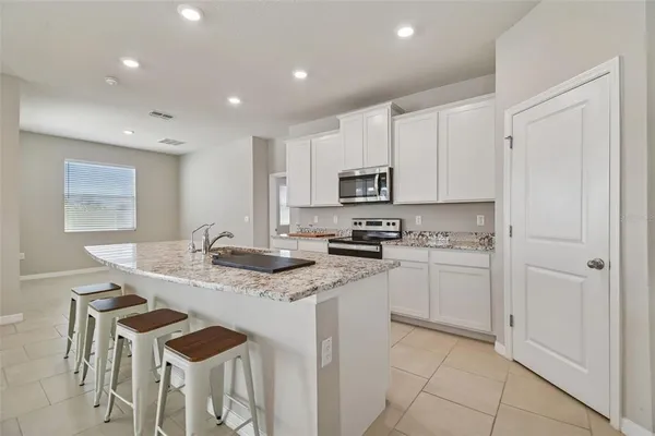 a kitchen with cabinets and chairs