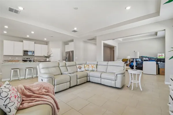 a living room with furniture white kitchen and a sink