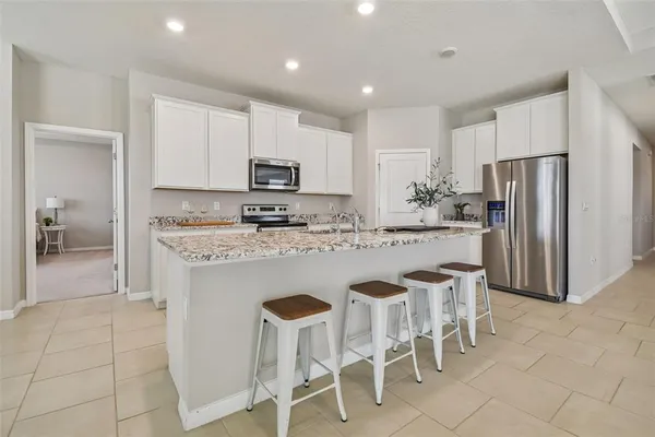a kitchen with stainless steel appliances granite countertop a white cabinets and a refrigerator