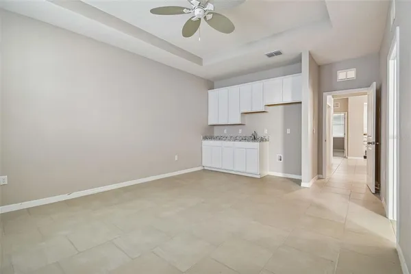 an empty room with windows and fan